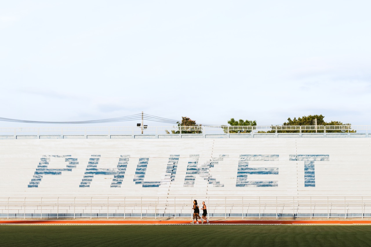 Runners passing the PHUKET grandstand at golden hour